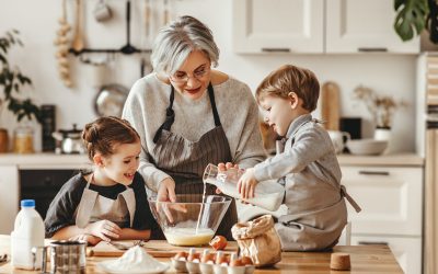 happy family grandmother and grandchildren cook in the kitchen, knead dough and bake cookies